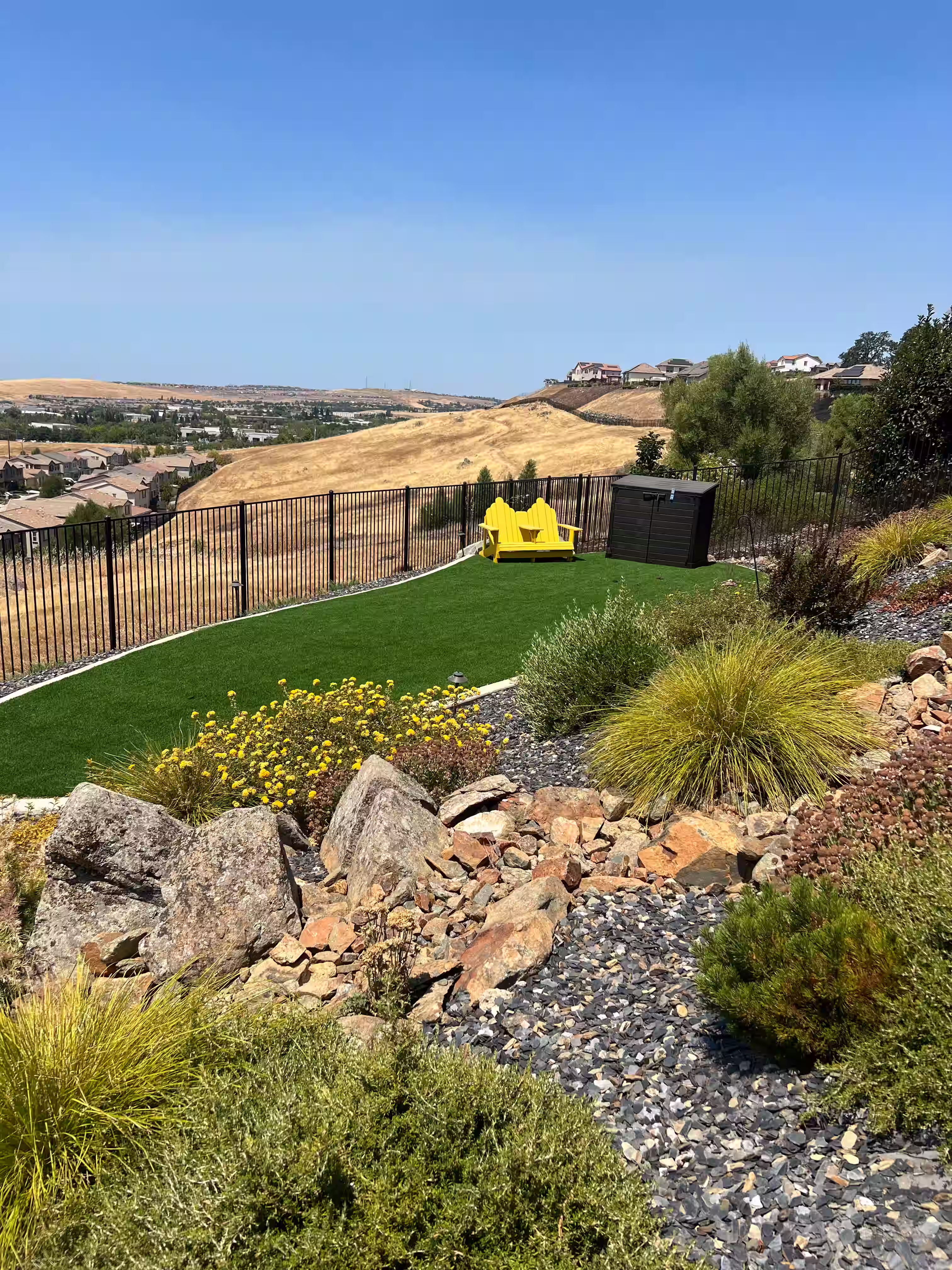 Artificial turf amongst hardscape and hillside landscaping