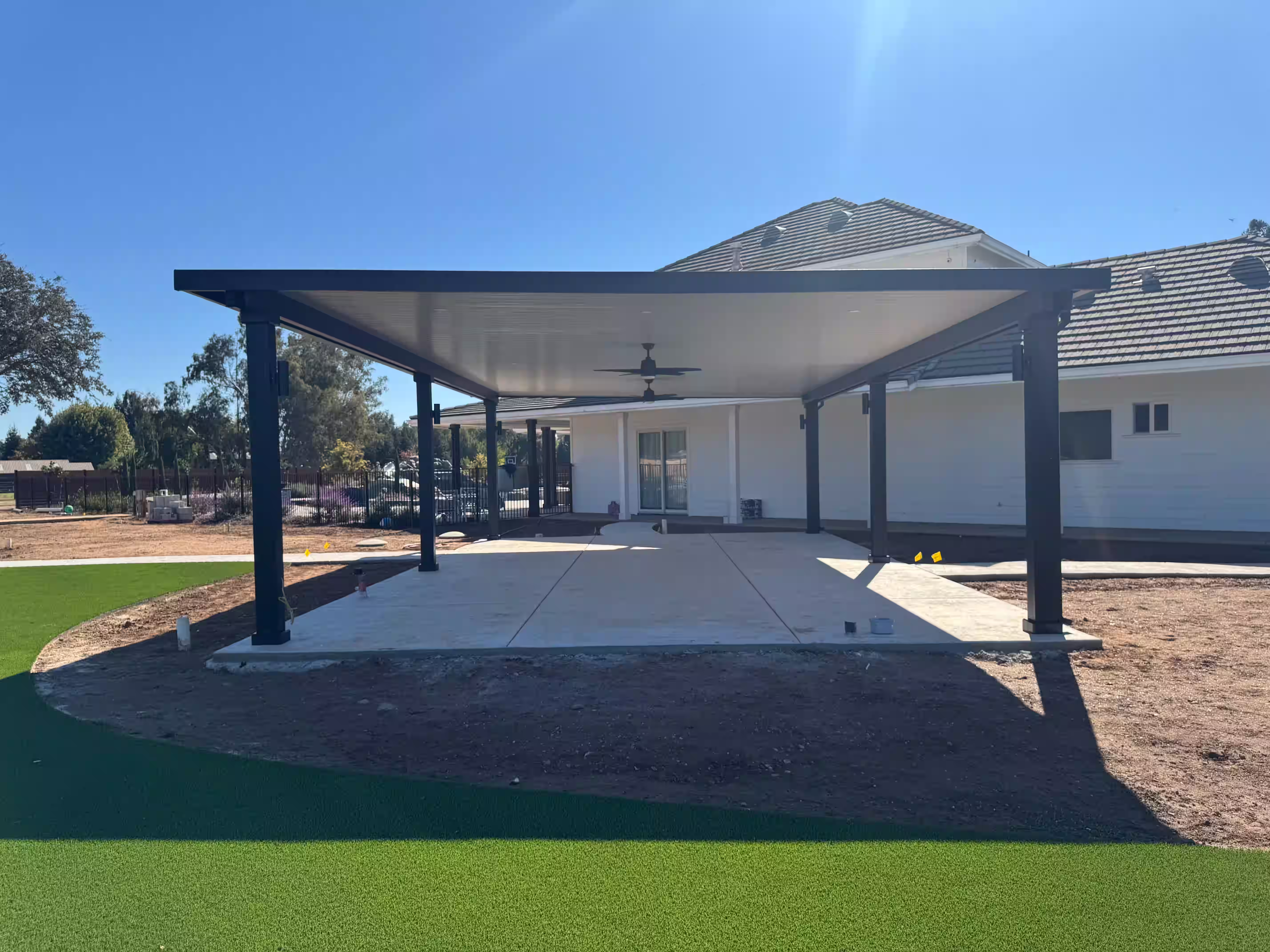 Artificial turf near a large outdoor patio and pergola