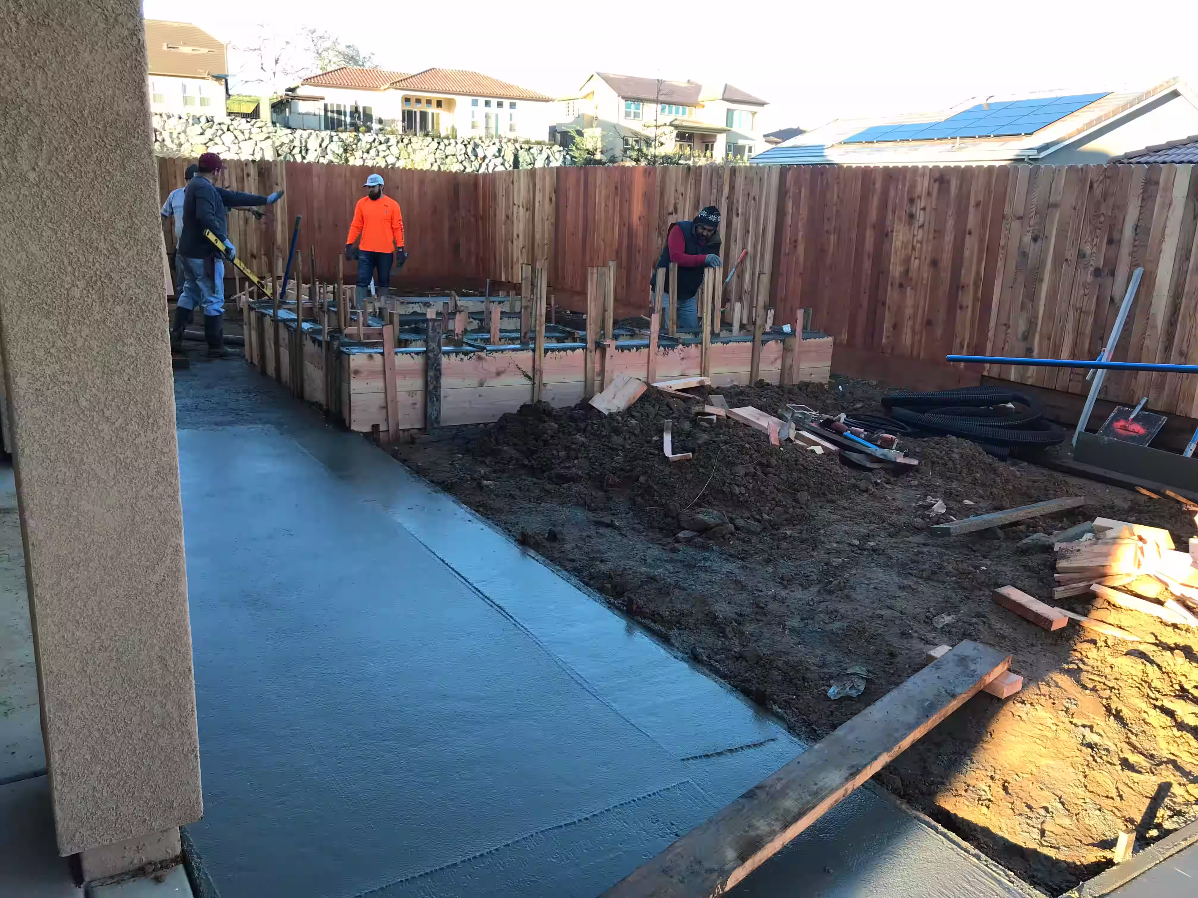 Outdoor renovation with a large concrete patio and concrete planter boxes