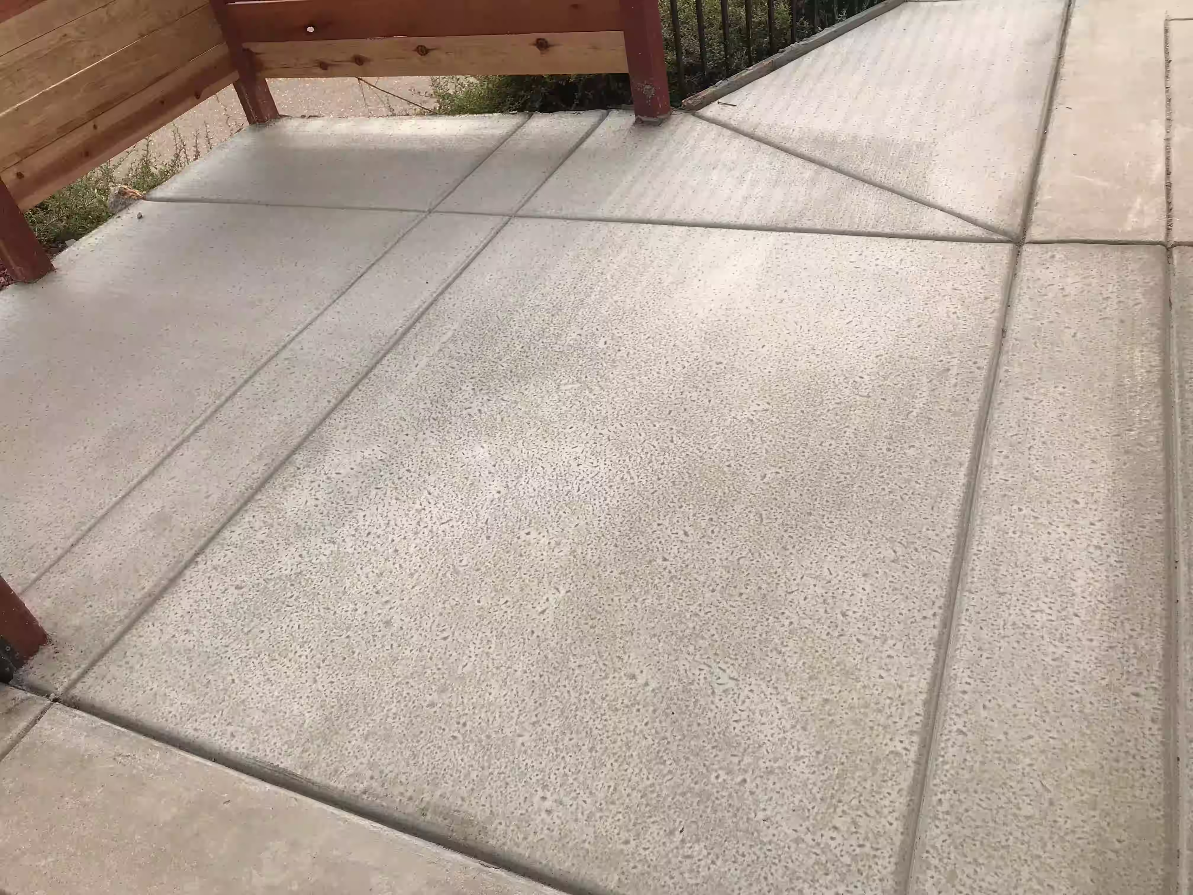 Concrete patio installation with metal and wooden fencing solutions