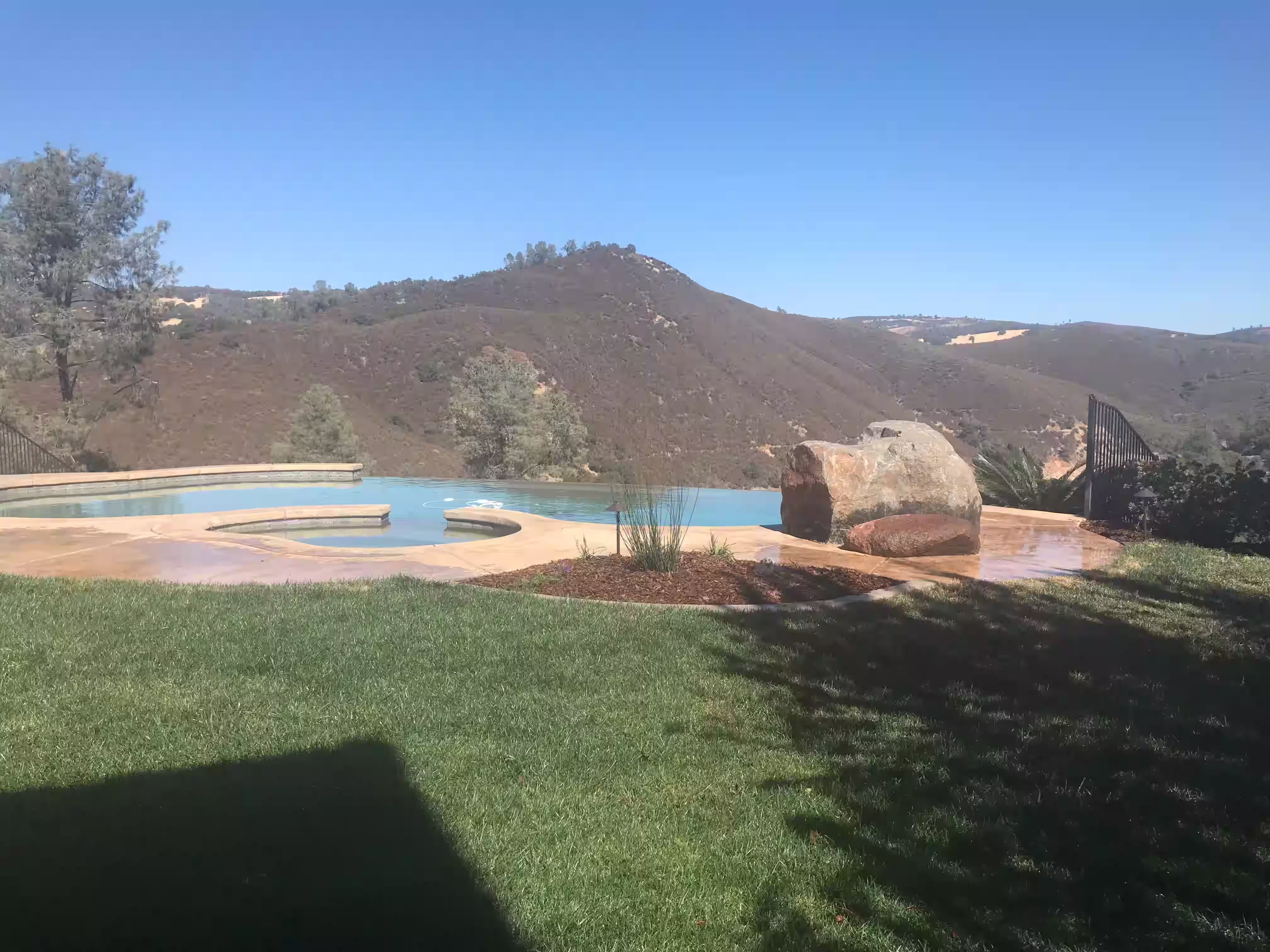 Poolside landscaping that integrates lawns and hardscape elements